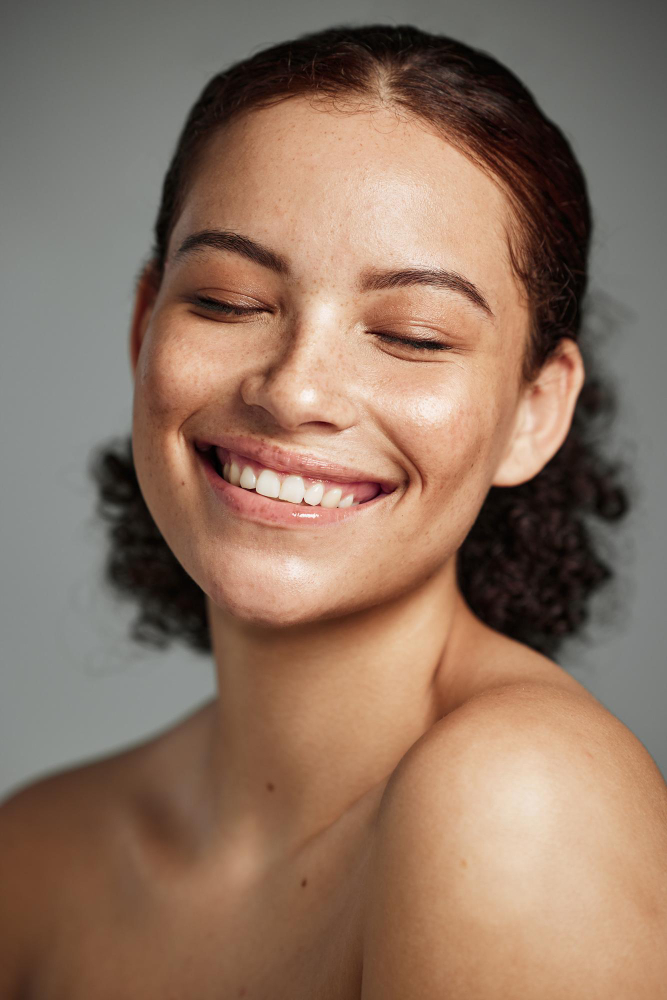 face-beauty-skincare-with-model-black-woman-studio-gray-background-promote-natural-care-facial-wellness-makeup-with-attractive-young-female-happy-with-her-skin-product